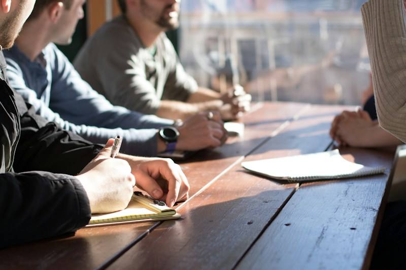 People reviewing paperwork in a meeting, representative image