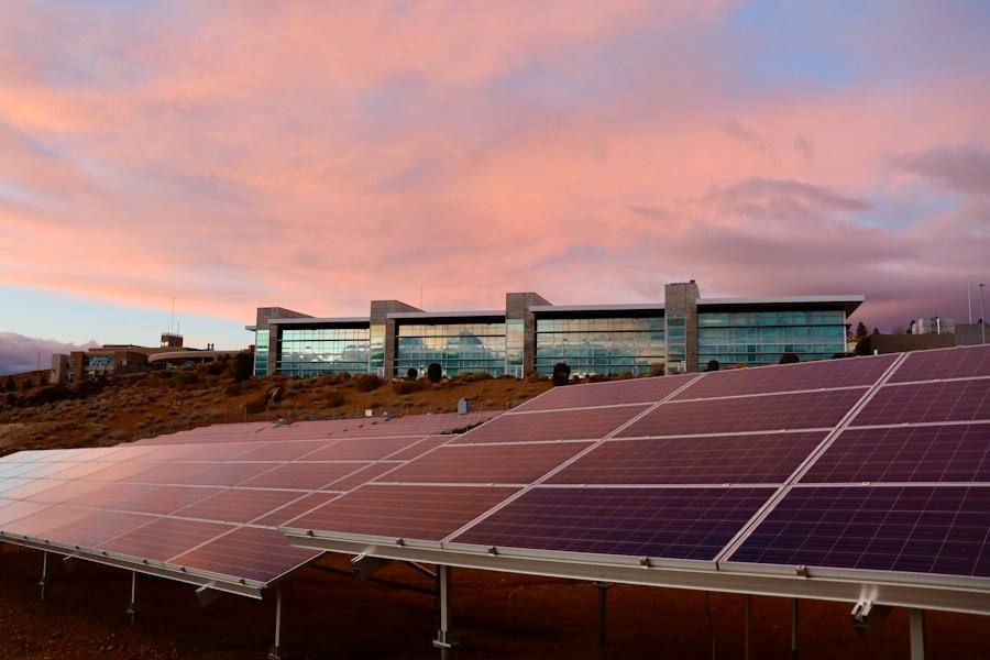 Solar panels on an open field under clouds, representative image